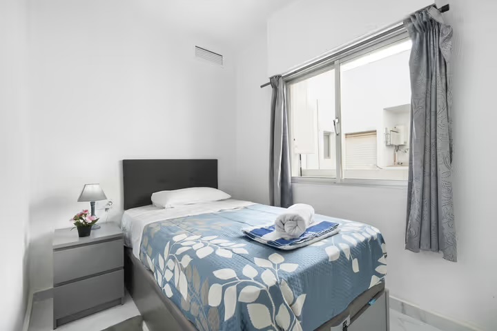 Single bedroom with natural light and balcony view